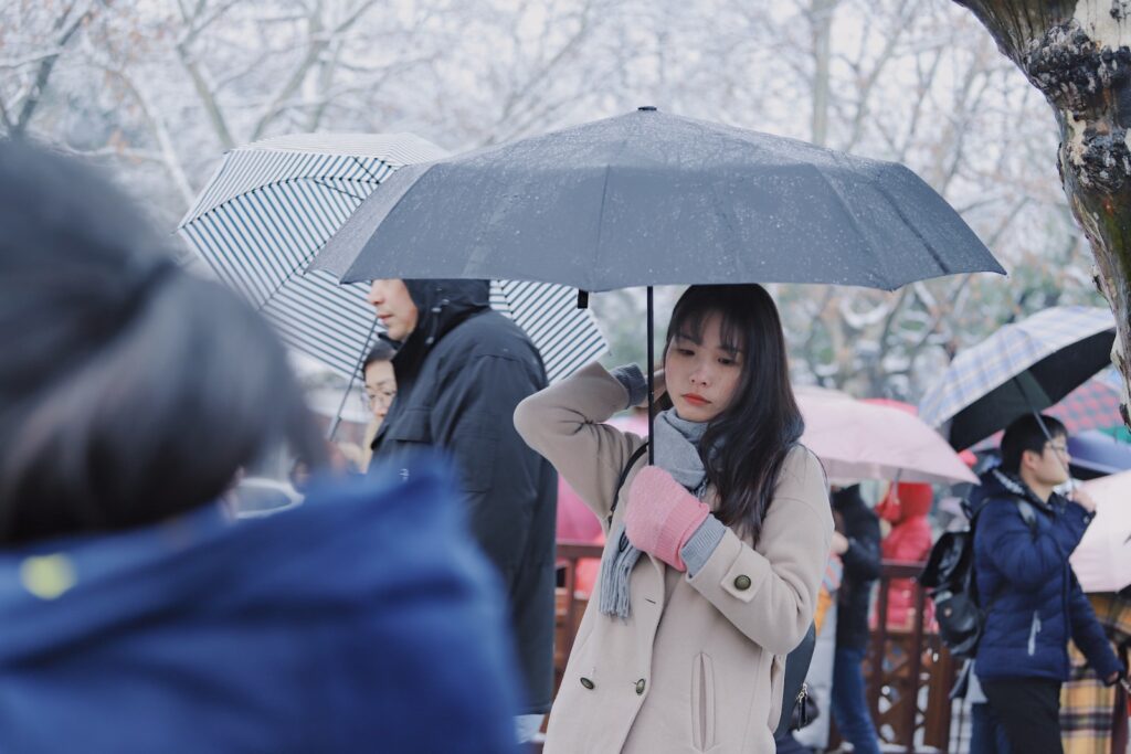 Minnesota woman in beige coat holding umbrella