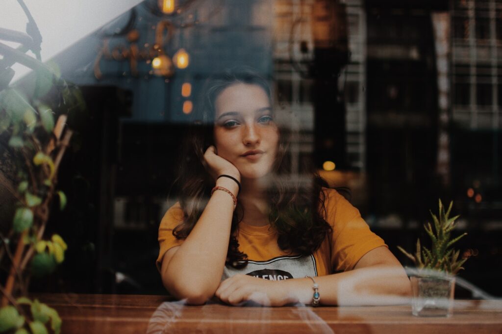 Minnesota woman experiencing abuse sitting next to table with hands on cheek